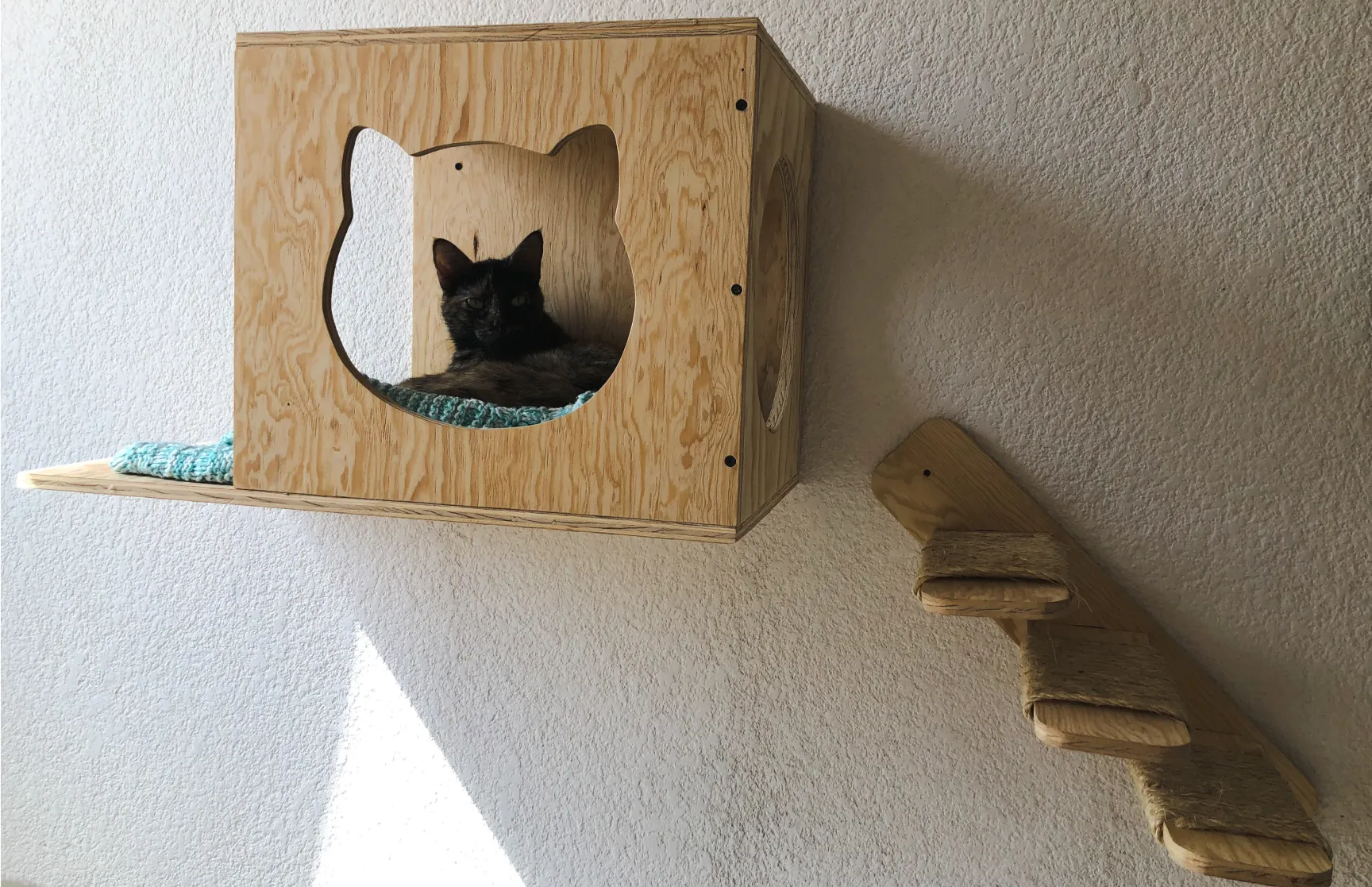gimnasios-para-gatos casa de gato de madera colocada en una pared con escaleras para que el gato entre a su refugio flotante fijado a la pared